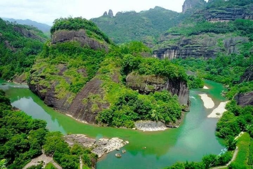 A river winding through a lush valley with steep cliffs and dense greenery. 4