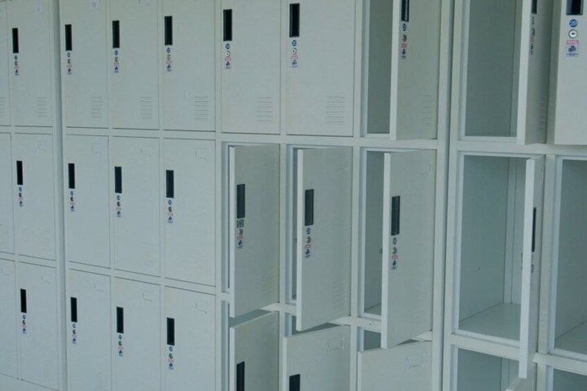 A row of white lockers with electronic keypads. 2