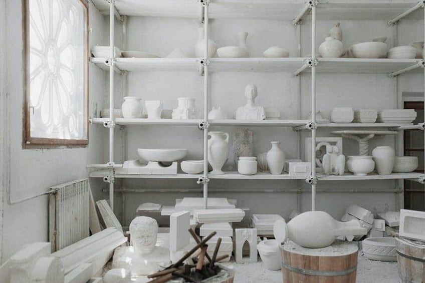 A pottery studio with shelves of white ceramic items. 2