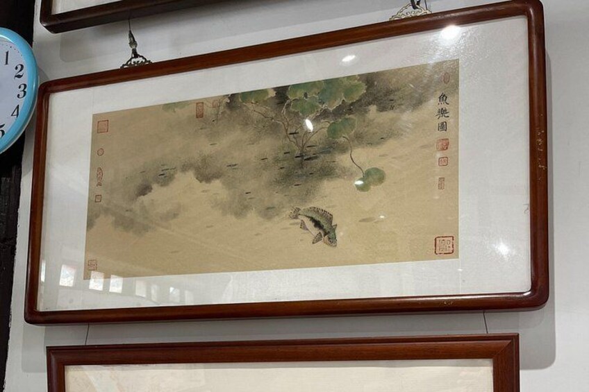 A framed traditional Chinese painting with calligraphy, mounted on a wall. 5