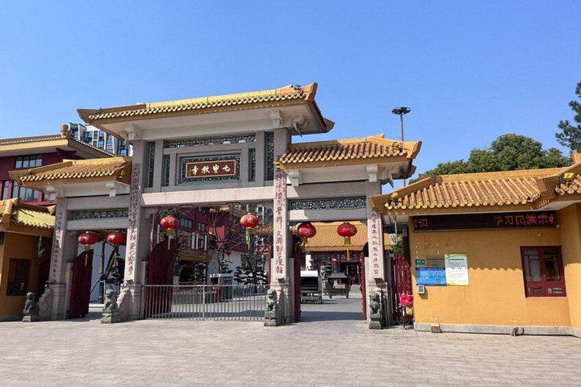 A traditional gate with Chinese characters, red lanterns, and a clear blue sky. 3