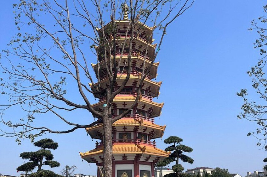 A multi-tiered pagoda with a tree in the foreground. 2