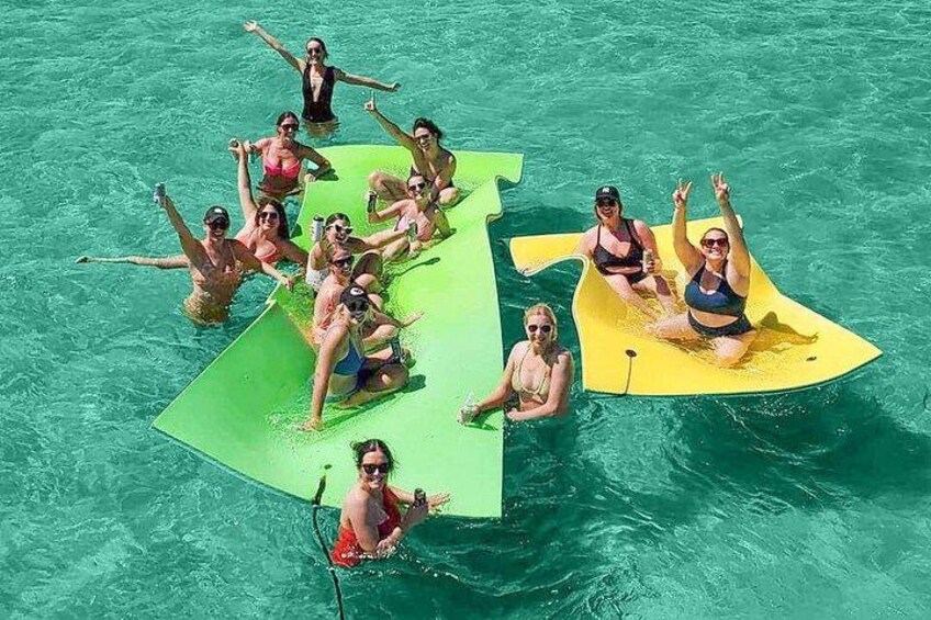 People on a green and yellow raft in a pool. 4