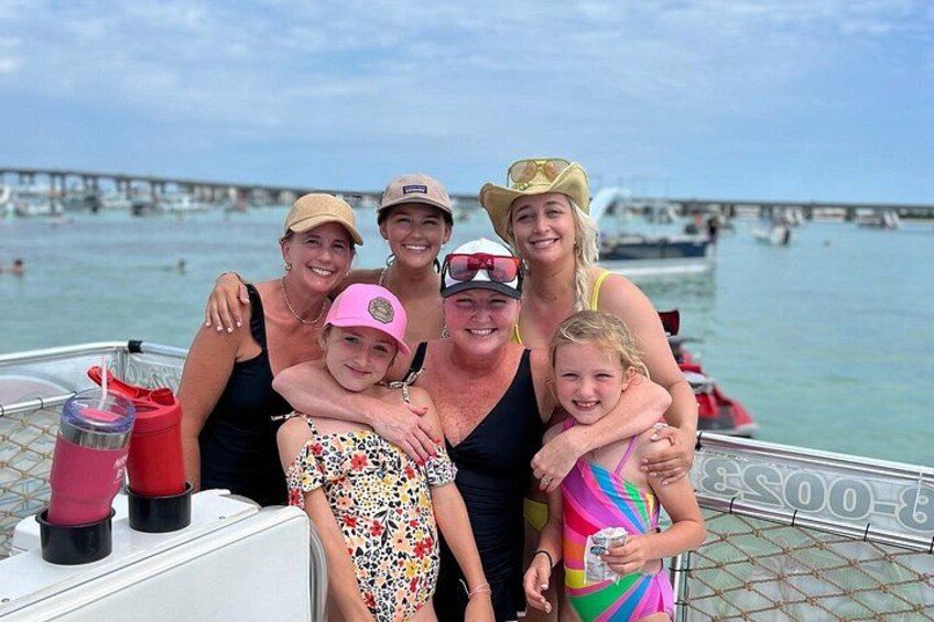 A group of people on a boat with a pier and water in the background. 2