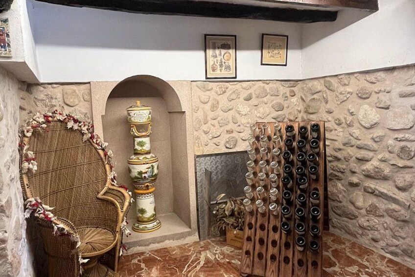 A wine cellar with a chair, a decorative urn, and a wine rack. 3