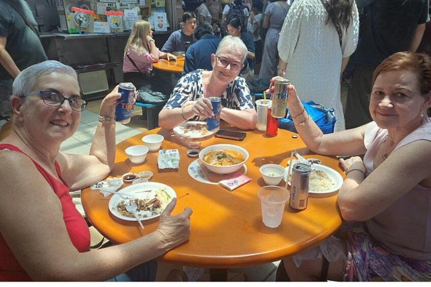 A group of people sitting around a table with food and drinks. 2