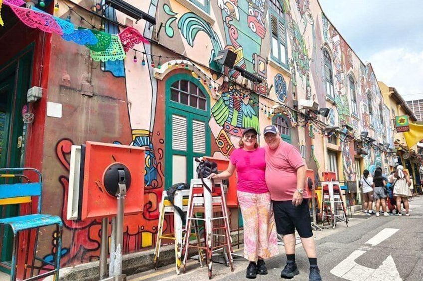 Une fresque colorée sur un bâtiment, une échelle et une personne debout. 5