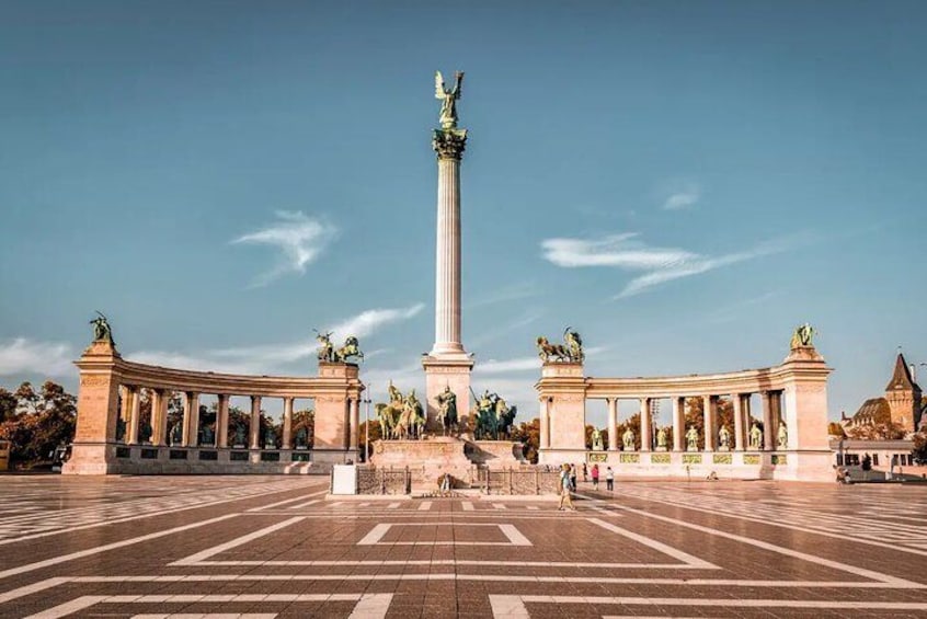 A large open plaza with a central monument, flanked by classical columns and statues. 5
