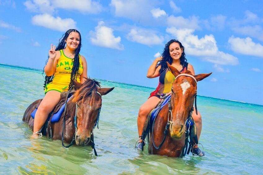 Deux personnes à cheval, évoluant dans une eau peu profonde, sous un ciel dégagé. 2