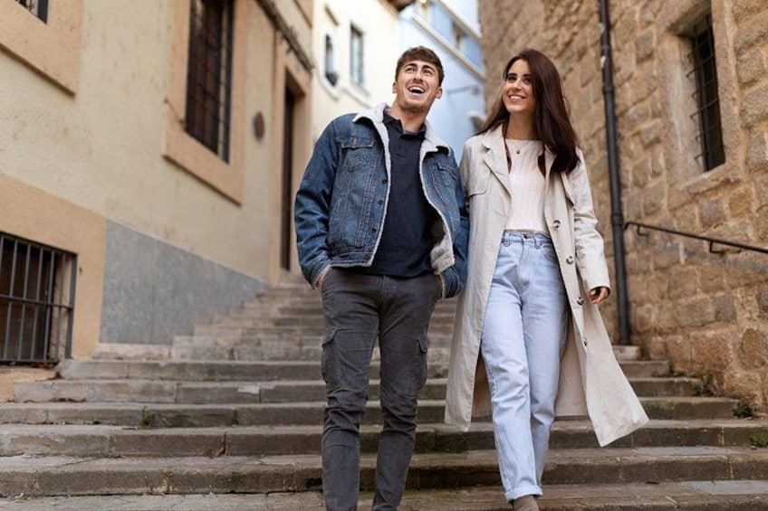 A couple walking down a stone staircase in an urban setting. 2