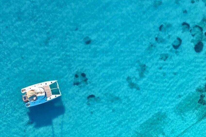 A small boat on clear turquoise water. 4