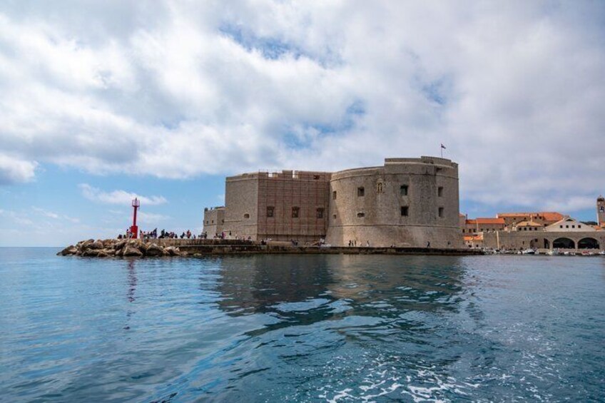 Une forteresse historique au bord de la mer, un phare et un ciel dégagé. 1