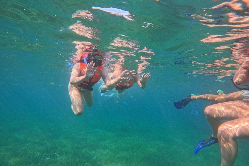 A person swimming underwater with fins and a camera. 4