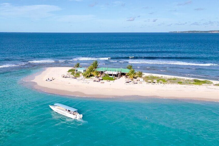 A tropical island with clear turquoise waters, a white sandy beach, and a small building surrounded by palm trees. 2