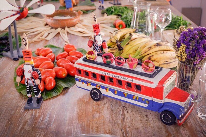 Een kleurrijke speeltrein, een tros bananen en een speelgoedfiguur op een houten tafel. 3