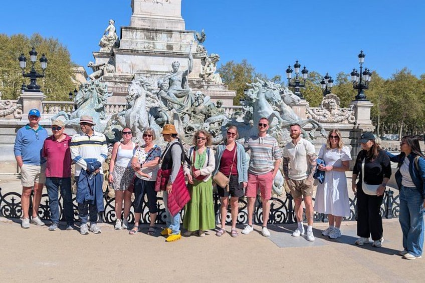 A group of people standing in front of a large fountain with statues. 5