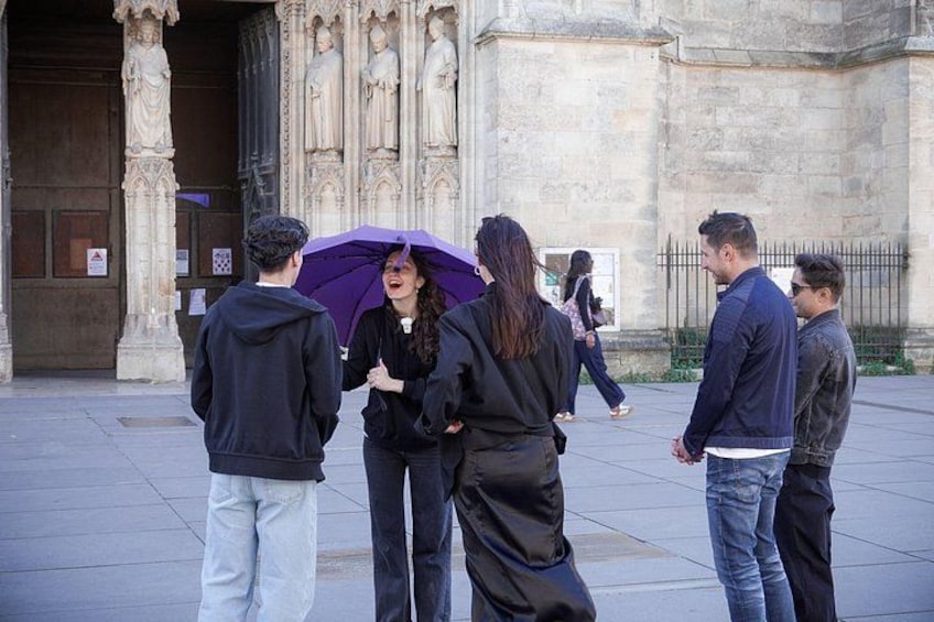 A group of people standing in front of a building with ornate architecture. 2