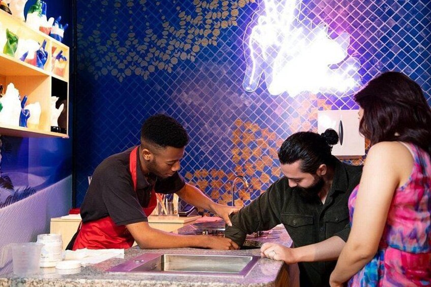 A person cutting a cake at a counter with a colorful tiled wall in the background. 4