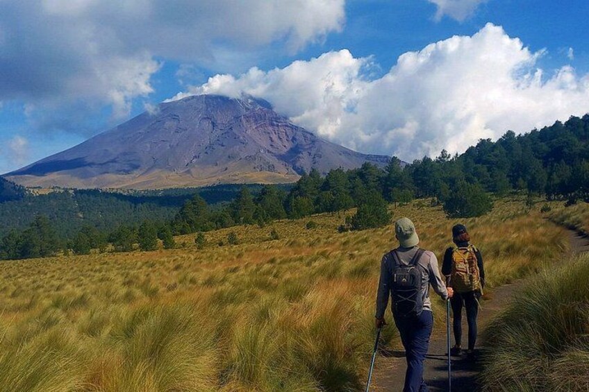 Dos excursionistas en un sendero con una montaña al fondo. 2
