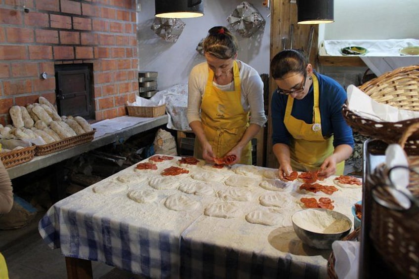 Zwei Personen bereiten Essen an einem Tisch mit Teig und Fleisch zu. 5