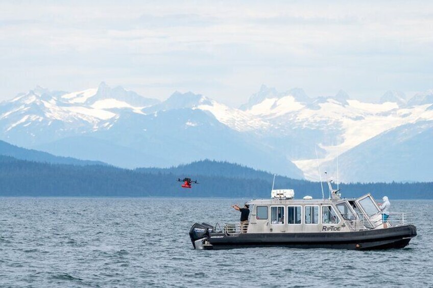A boat on a lake with mountains in the background. 2