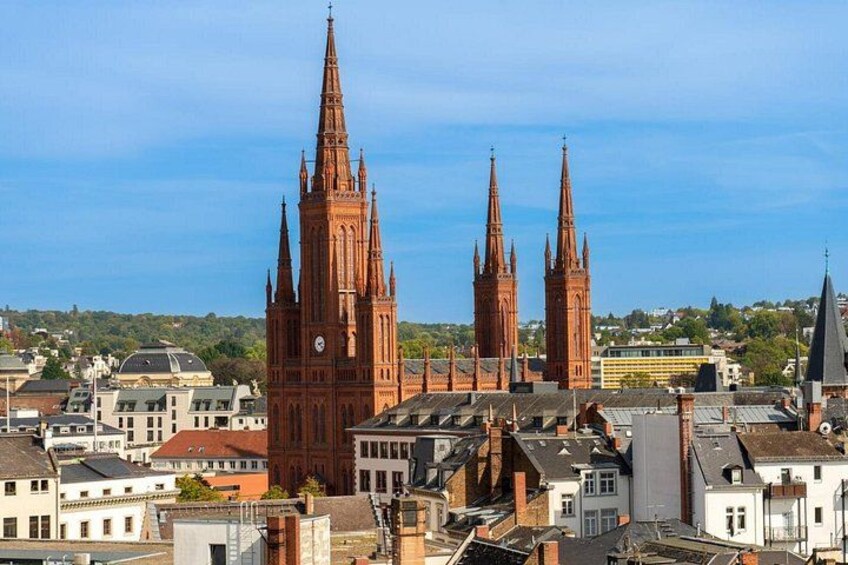 Une vue urbaine mettant en valeur d’imposantes cathédrales gothiques rouges et les bâtiments environnants. 5