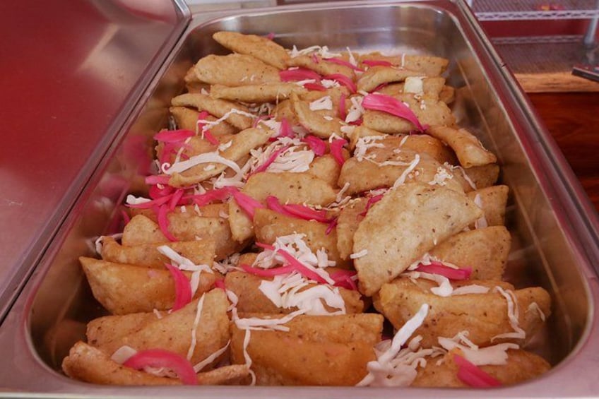 Ein Tablett mit Lebensmitteln, möglicherweise Snacks, mit geriebenem Käse und rosa Gemüsestreifen. 4