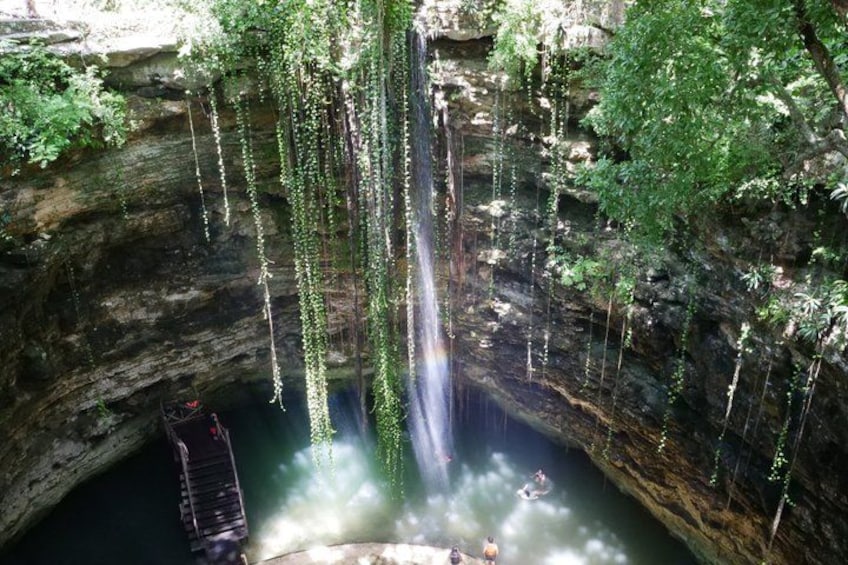 Een waterval stort in een zwembad, omringd door rotsachtige kliffen en begroeiing. 3