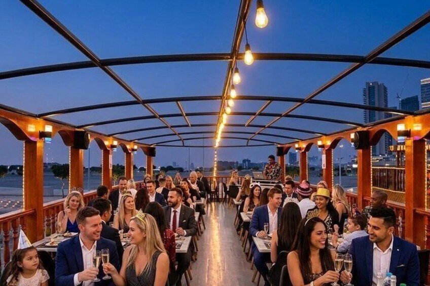 A covered dining area with tables and chairs, a railing, and a cityscape in the background. 4