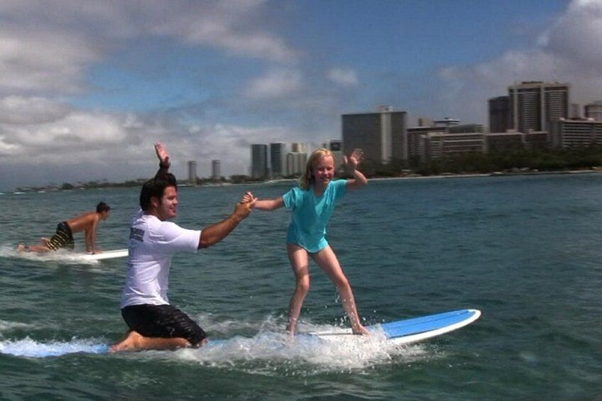 A person surfing with a city skyline in the background. 1