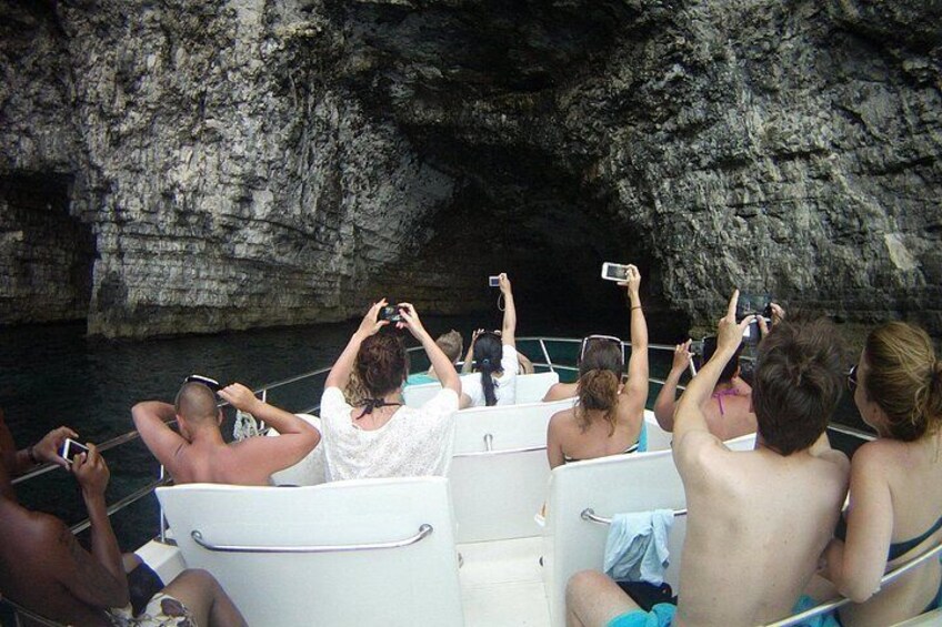 People on a boat near a rocky cave entrance. 5