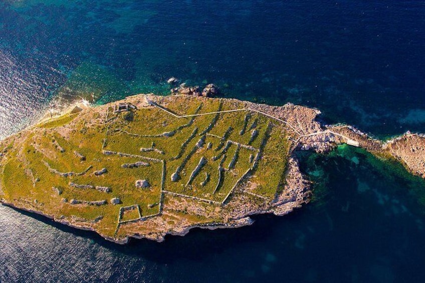 An aerial view of an island with distinct terraced fields and a coastline. 4