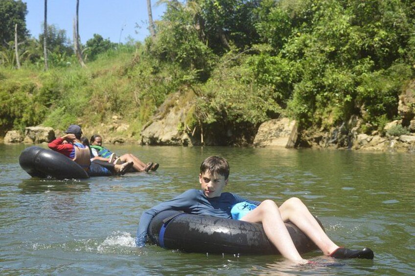 People floating on water tubes in a river surrounded by greenery. 2