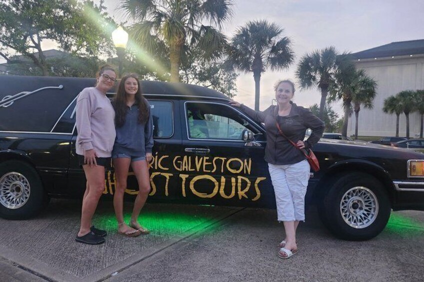 Tre personer poserer foran en sort varevogn, hvor der står 'RIC GALVESTON TOUR'. 3