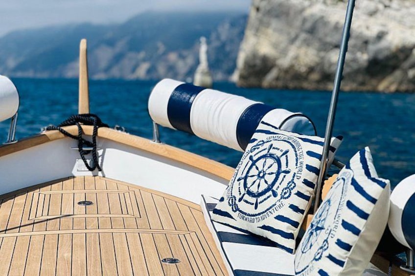 A boat's deck with a wooden floor, a steering wheel, and life rings. 3