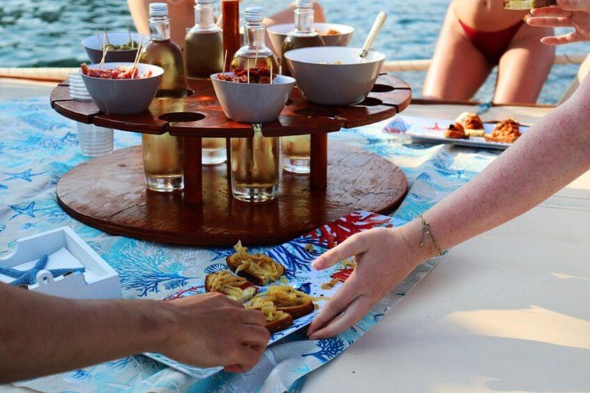 A dining table with a seafood platter, bowls, and bottles of beverages. 5