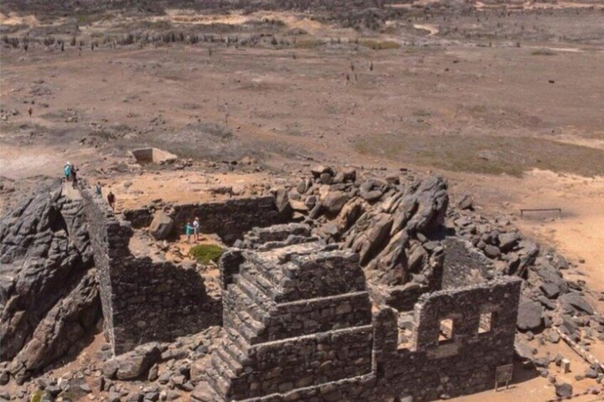 Ancient ruins with stone structures and a sandy landscape. 3