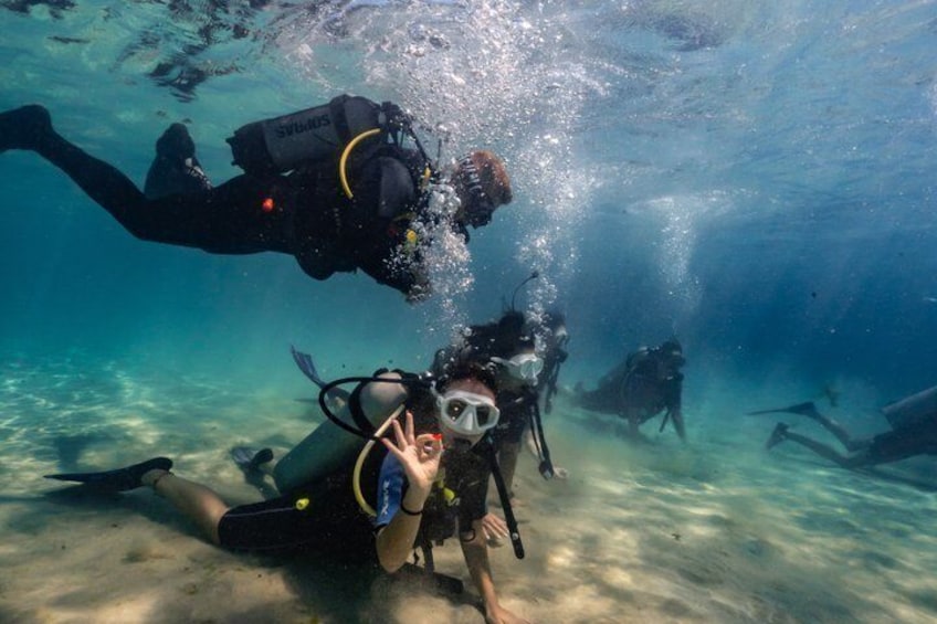 Taucher erkundet die Unterwasserwelt mit Tauchausrüstung, klares Wasser und sandiger Meeresboden. 4