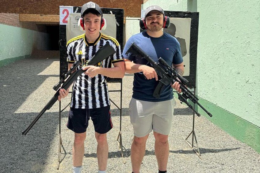 To personer holder geværer på et udendørs skyddeområde. 1