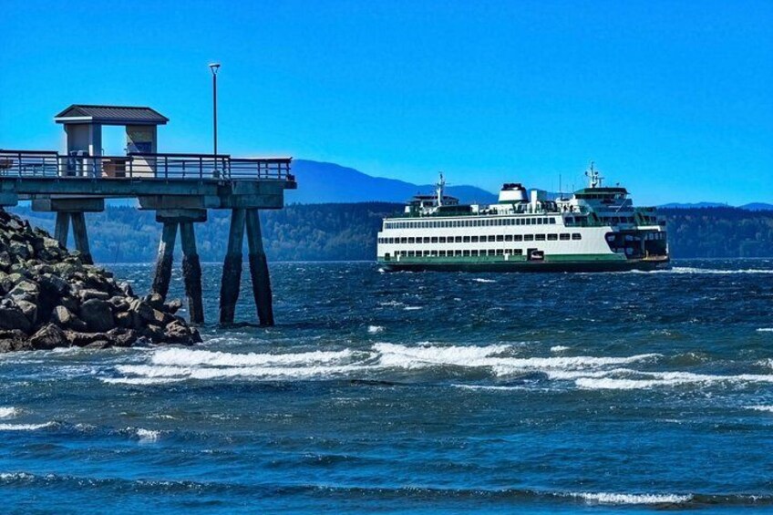 Un ferry en una masa de agua con un muelle y un paisaje montañoso. 1