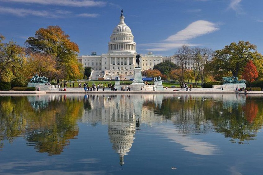 El Capitolio de los Estados Unidos, un gran domo blanco, y un estanque reflectante al frente. 2