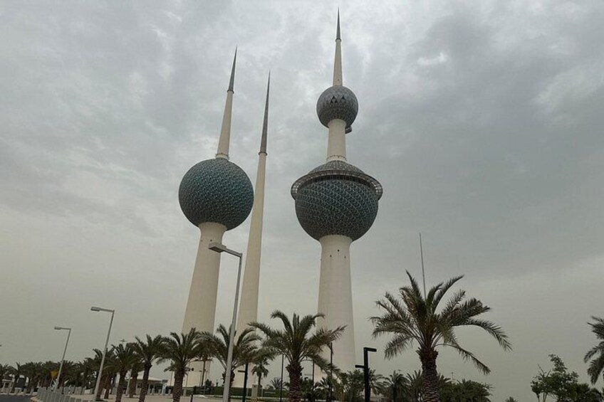 Two tall towers with spherical tops and spires, surrounded by palm trees. 4