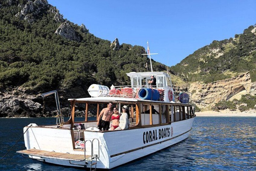 Un bote llamado 'CORAL BOATS' en una masa de agua con acantilados rocosos al fondo. 2