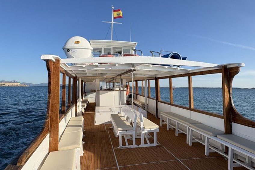 Ein Bootsdeck mit weißen Bänken und einer Flagge. 5