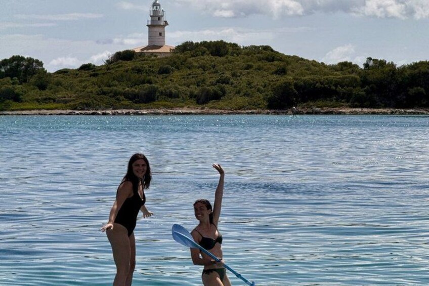 Zwei Personen im Wasser, im Hintergrund ein Leuchtturm. 2