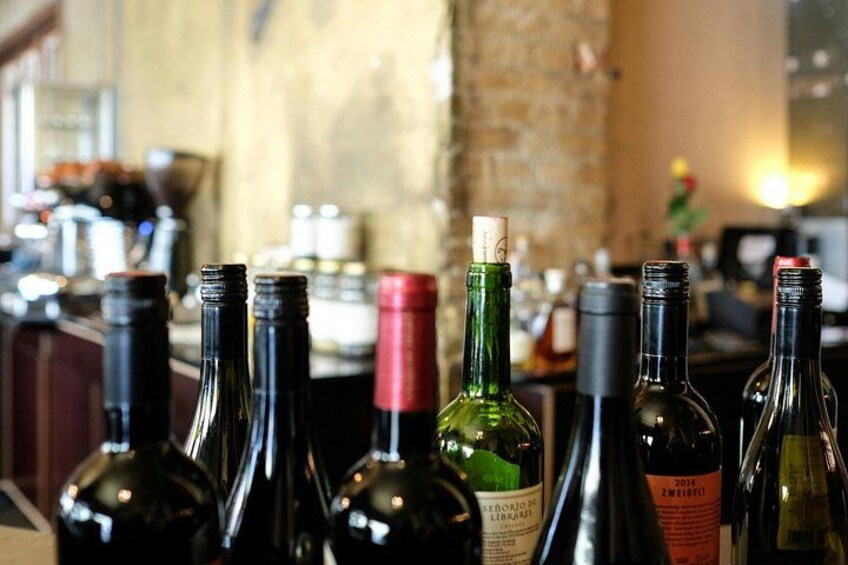 A row of wine bottles on a bar counter with a brick wall in the background. 5