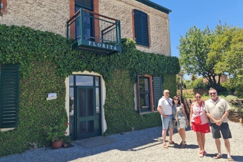 A building with 'FLORITA' signage, ivy-covered walls, a door, and a small balcony. 4