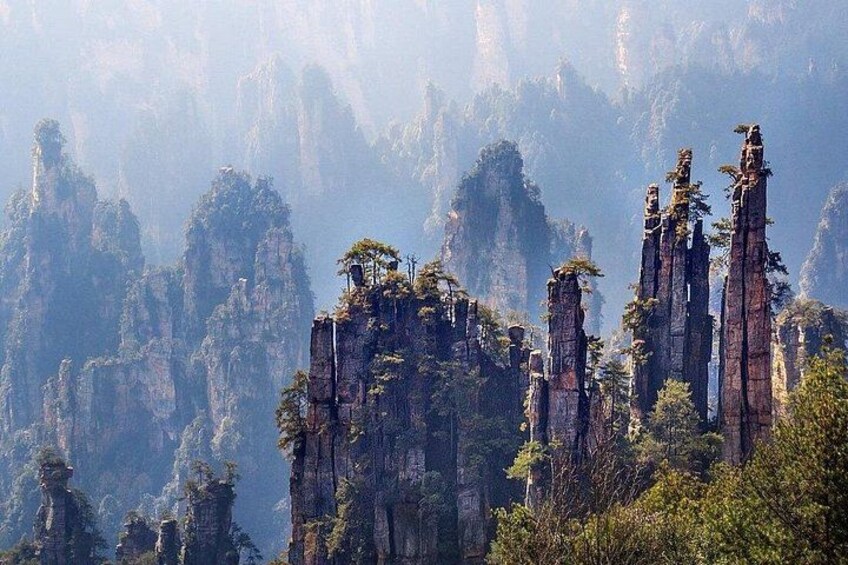 A mountainous landscape with tall, narrow rock formations and sparse vegetation. 4