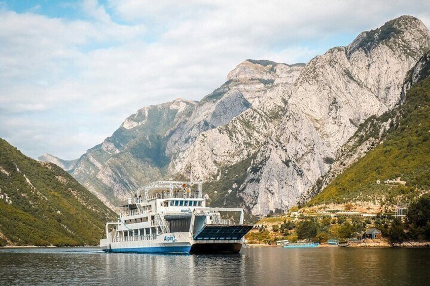 A boat on a river with mountains in the background. 1