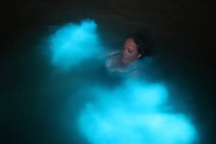 A person in a body of water with blue light effects. 2